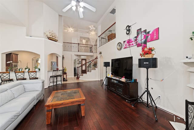 living room featuring a high ceiling, ceiling fan, and dark hardwood / wood-style flooring