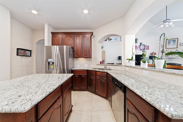 kitchen with sink, light tile patterned floors, backsplash, appliances with stainless steel finishes, and a center island