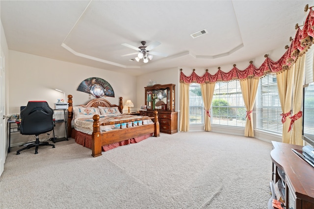 carpeted bedroom featuring a raised ceiling, access to outside, and ceiling fan