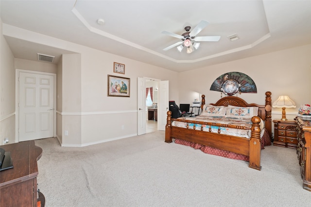 bedroom with light carpet, a tray ceiling, and ceiling fan