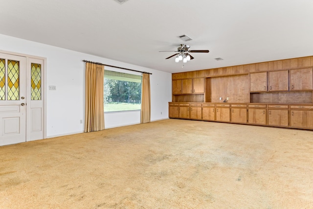 unfurnished living room featuring ceiling fan and light colored carpet