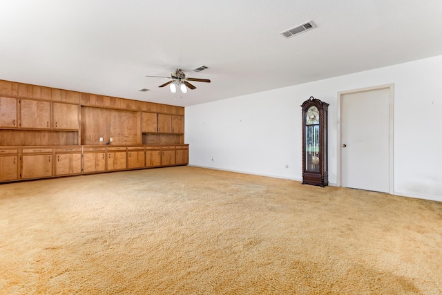 unfurnished living room featuring ceiling fan and light carpet