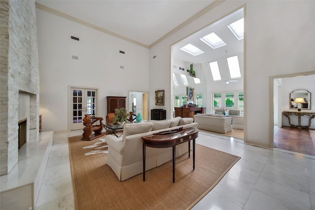 living room featuring light tile patterned floors, a fireplace, a high ceiling, crown molding, and french doors