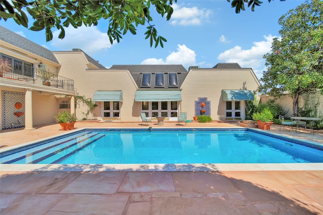 view of swimming pool featuring a patio and french doors