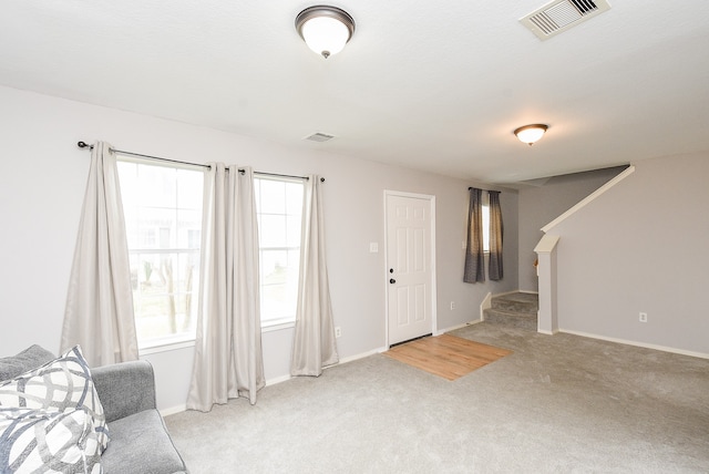 unfurnished living room featuring light colored carpet