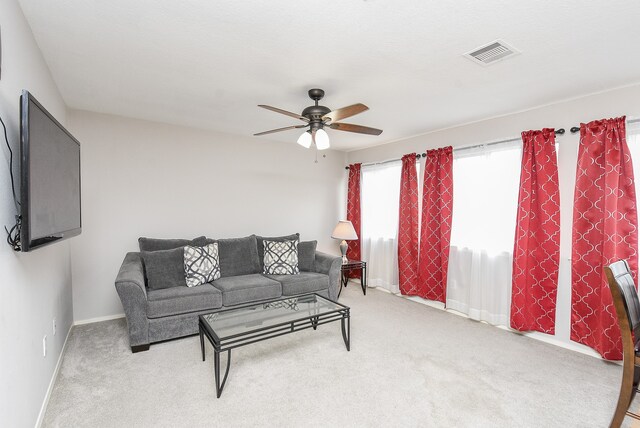 carpeted living room with ceiling fan