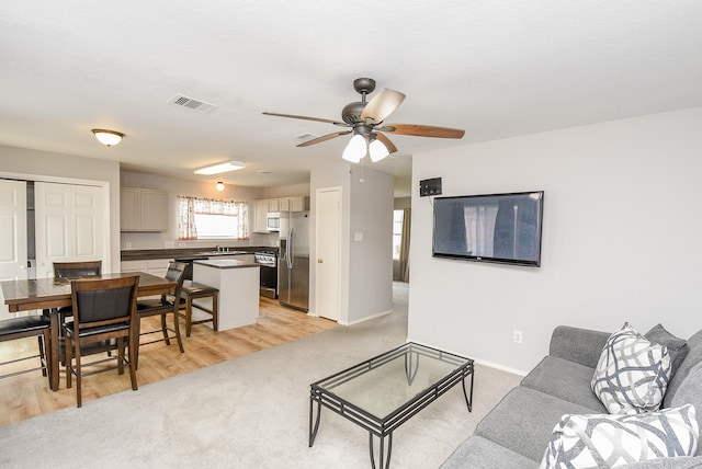 living room with light wood-type flooring and ceiling fan