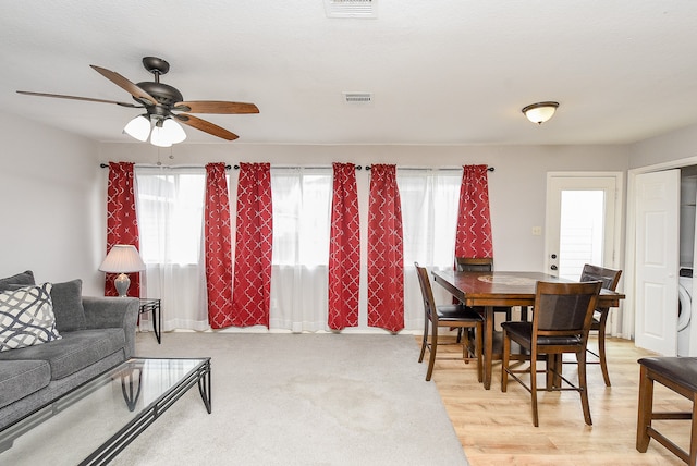 living room featuring washer / dryer, ceiling fan, and light hardwood / wood-style flooring