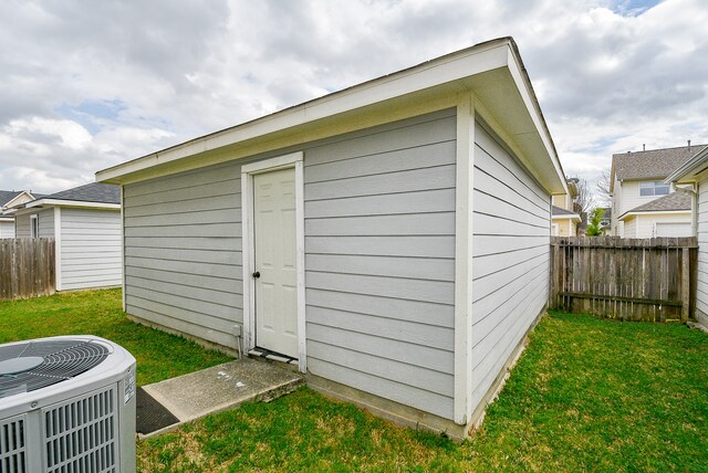 view of outbuilding featuring a lawn and cooling unit