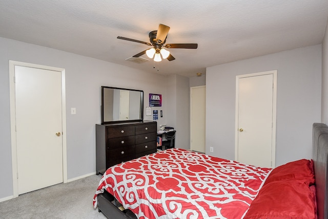 bedroom with a textured ceiling, ceiling fan, and light colored carpet