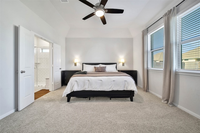 carpeted bedroom with connected bathroom, vaulted ceiling, and ceiling fan