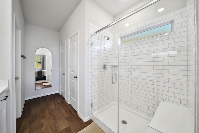 bathroom featuring wood-type flooring, vanity, and a shower with door