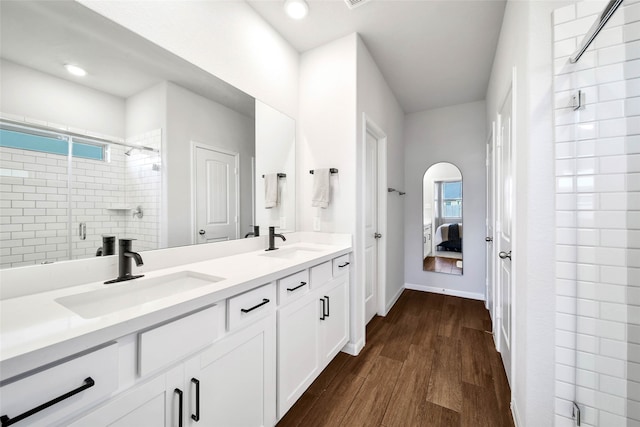 bathroom featuring vanity, hardwood / wood-style floors, a shower with door, and a healthy amount of sunlight