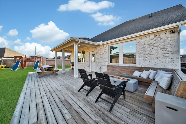 wooden deck with a lawn, an outdoor living space, and a playground