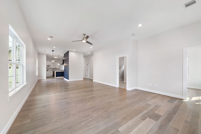 unfurnished living room featuring light hardwood / wood-style flooring and ceiling fan