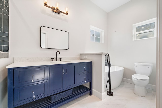 bathroom with vanity, a tub to relax in, plenty of natural light, and toilet