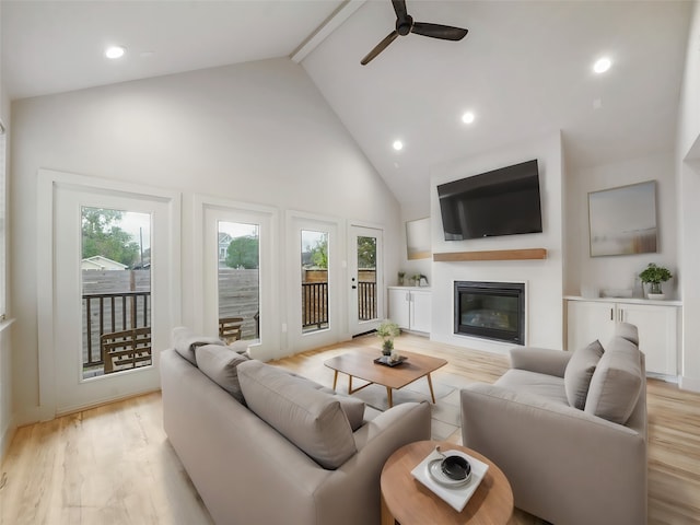 living room featuring ceiling fan, beamed ceiling, light hardwood / wood-style flooring, and high vaulted ceiling