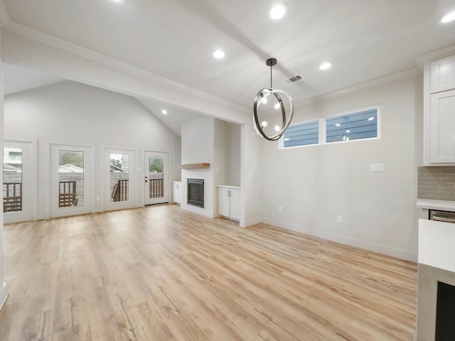 unfurnished living room with light hardwood / wood-style flooring, vaulted ceiling, and ornamental molding