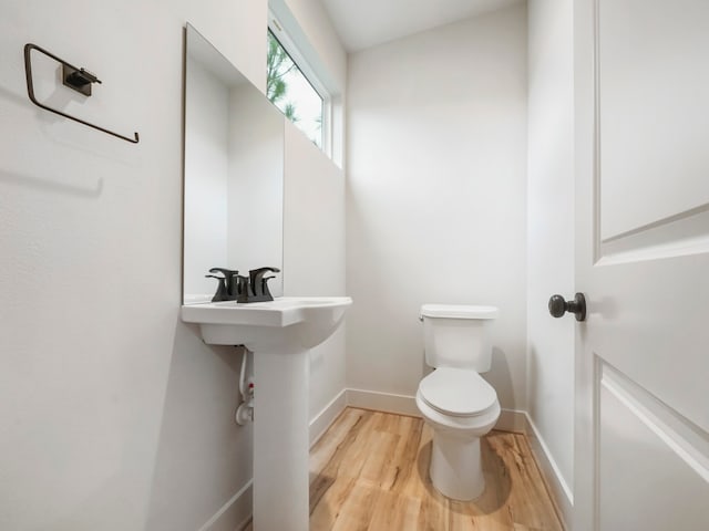 bathroom with hardwood / wood-style floors and toilet