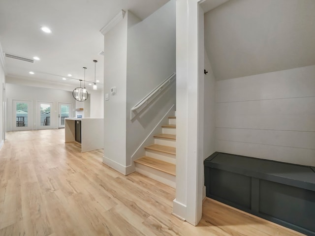 stairway featuring a notable chandelier and hardwood / wood-style floors