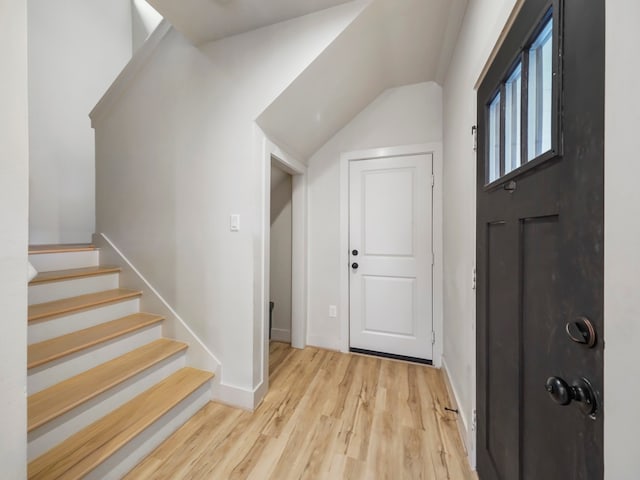 entryway featuring light wood-type flooring and vaulted ceiling