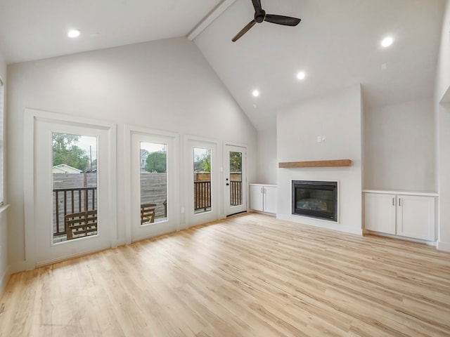 unfurnished living room with light hardwood / wood-style floors, beam ceiling, ceiling fan, and high vaulted ceiling