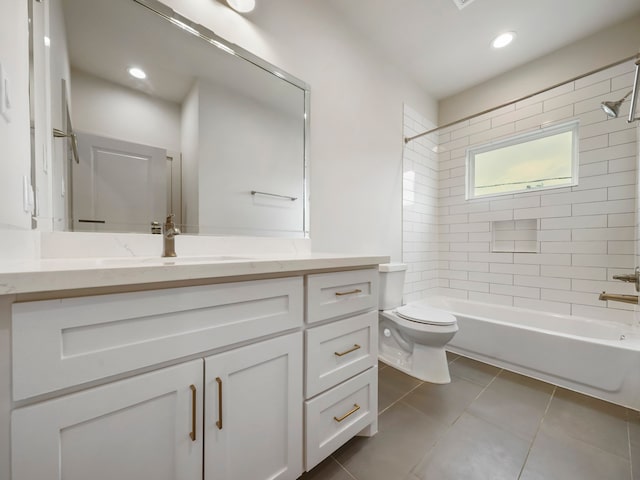 full bathroom featuring tiled shower / bath, vanity, tile patterned flooring, and toilet