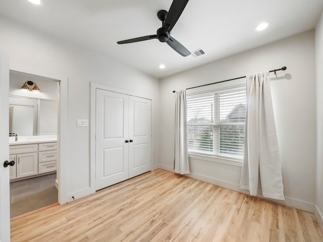 unfurnished bedroom with ceiling fan, sink, ensuite bath, and light hardwood / wood-style floors