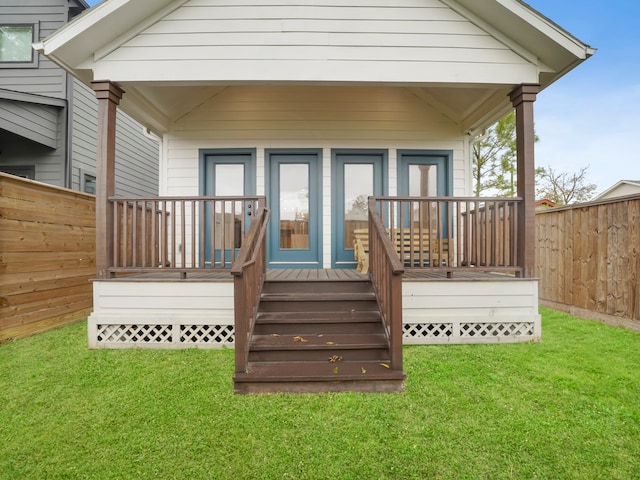 rear view of property with a wooden deck and a lawn