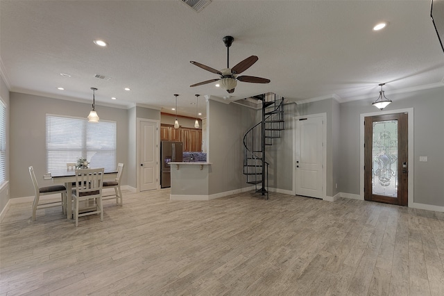 interior space featuring light hardwood / wood-style flooring, a textured ceiling, ceiling fan, and crown molding