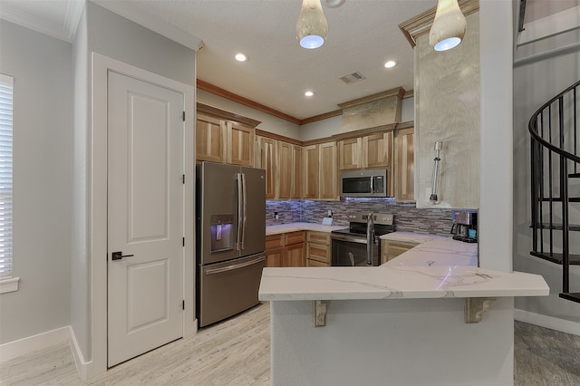 kitchen with appliances with stainless steel finishes, kitchen peninsula, a textured ceiling, a kitchen bar, and ornamental molding