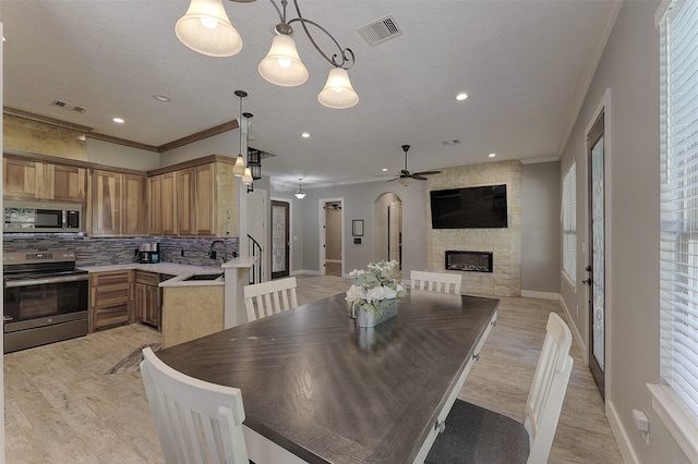 dining area with light wood-type flooring, plenty of natural light, and ornamental molding