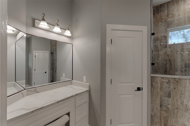 bathroom with walk in shower and vanity