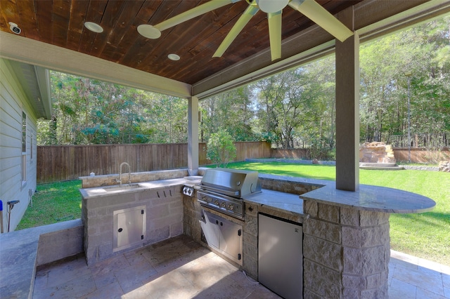 view of patio / terrace with ceiling fan, a grill, an outdoor kitchen, and sink