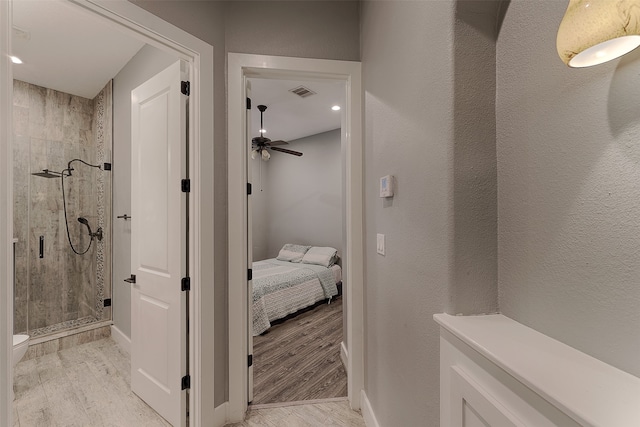 bathroom featuring wood-type flooring, ceiling fan, and an enclosed shower