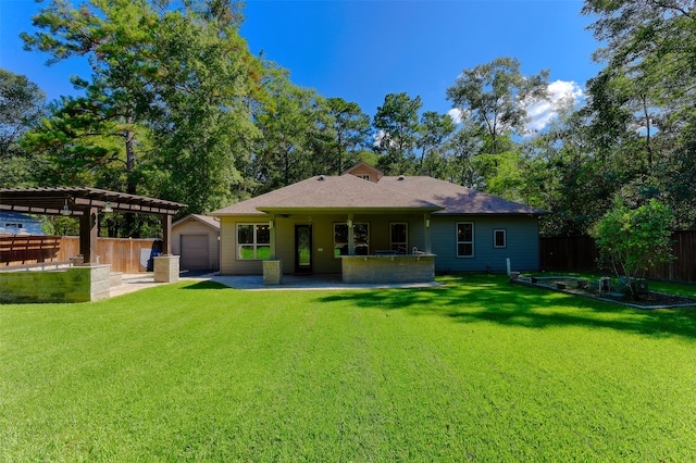 rear view of property with a lawn, a pergola, a garage, and a patio