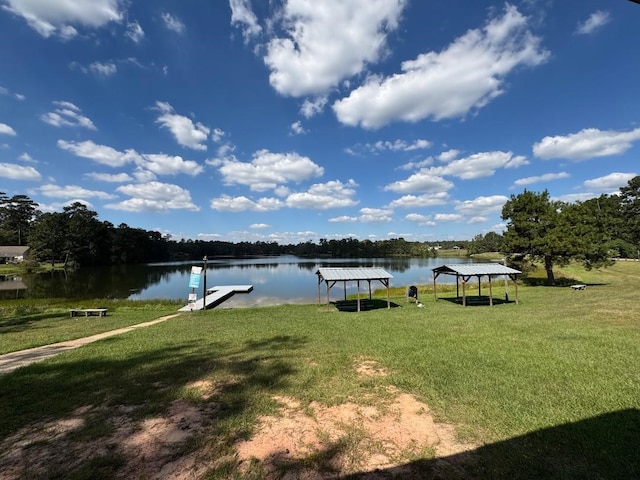 view of dock with a water view and a yard