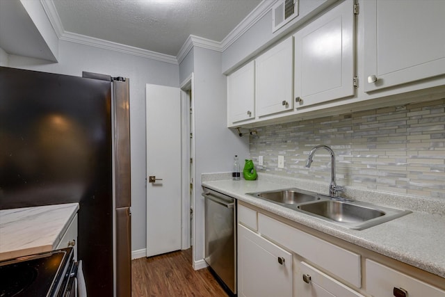 kitchen with appliances with stainless steel finishes, dark hardwood / wood-style flooring, tasteful backsplash, sink, and white cabinetry