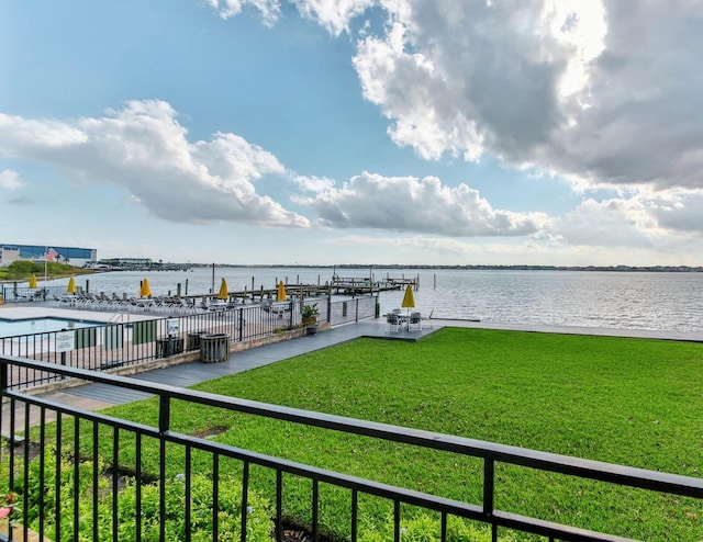 dock area featuring a yard, a water view, and a community pool