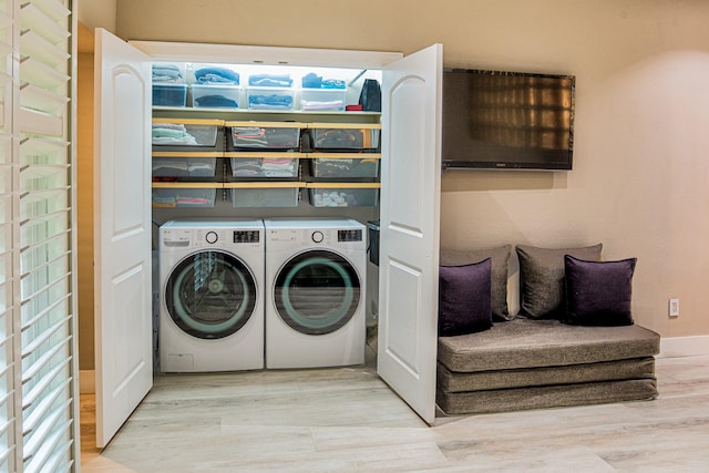 laundry area with separate washer and dryer and light hardwood / wood-style floors