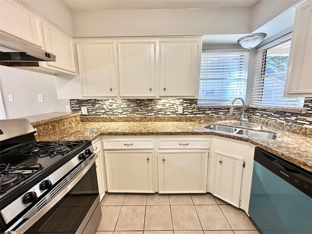 kitchen with dark stone counters, tasteful backsplash, sink, white cabinetry, and stainless steel appliances