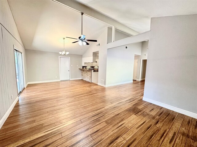 unfurnished living room with light hardwood / wood-style flooring, ceiling fan with notable chandelier, and high vaulted ceiling