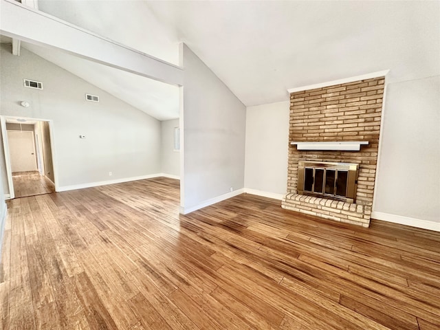 unfurnished living room with beamed ceiling, hardwood / wood-style flooring, a fireplace, and high vaulted ceiling