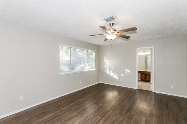 unfurnished room with ceiling fan, dark wood-type flooring, and a textured ceiling