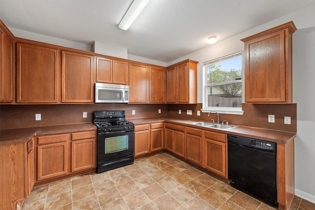 kitchen with black appliances, a textured ceiling, and sink