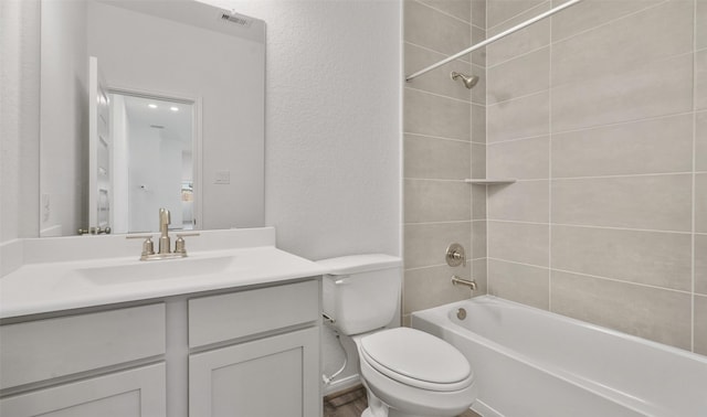 full bathroom with tiled shower / bath combo, vanity, and toilet