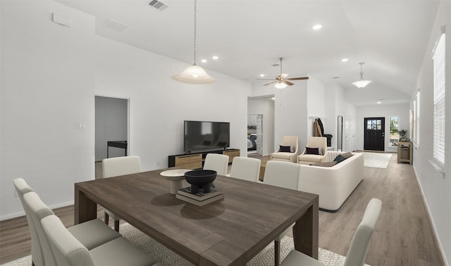 dining area featuring ceiling fan, high vaulted ceiling, and light hardwood / wood-style flooring