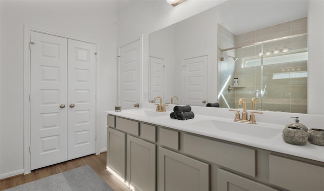 bathroom featuring hardwood / wood-style flooring, vanity, and an enclosed shower