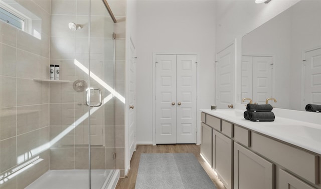 bathroom featuring wood-type flooring, vanity, and walk in shower