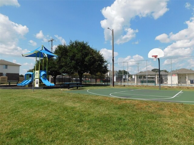 view of sport court featuring a lawn and a playground